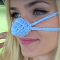 Close-up of a hand-knitted light blue nose warmer accessory worn by a female model - 5CM Diameter / Lake Blue