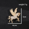 Golden pegasus brooch with crystal pavé and black gem eye on dark textured background - Xd825335