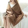 Brown plaid cashmere-feel scarf with tassels worn by a model in a cozy home setting - Khaki