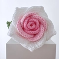 Handmade crochet rose flower in pink and white yarn on a white display block - Thai Rose White-Edged Pink