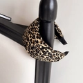Close-up of leopard print wide headband with soft fabric texture on a bedpost display - Coffee Leopard