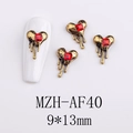 Macro view of gold heart alloy nail charms with red gemstones and melting drip effect - AF40-Gold Edge Red Square Gem Heart
