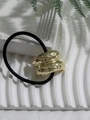Macro detail of a hammered gold metal ring on a black elastic ponytail holder - Style 6 (Gold Thickened Hammered)