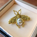 Detailed macro view of a vintage bee brooch with pearl and signature GG logo engraving - Bee Faux Pearl Style (7#)