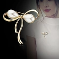 Elegante spilla a fiocco dorata con perle bianche e strass su una camicia bianca - Fiocco Dorato Perla
