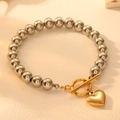 Dettaglio del bracciale a sfere in acciaio con chiusura OT e ciondolo a cuore - Stile Cuore Dorato (I501)