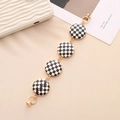 Close-up of black and white checkerboard pattern charm chain with gold metal links - K719 Round Leather Black White Grid