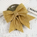 Detail view of a golden sequin Christmas bow decoration on textured plaster with faux snow - No.3 25*27CM (1pc) / Gold