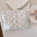 Detalle macro de la bolsa de maquillaje de algodón acolchado con estampado floral - Flor a rayas
