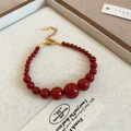 Detailansicht der roten Perlenarmband mit Farbverlauf und verstellbarem Goldverschluss - Armband-Goldverschluss-Rot