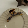 Close-up of tortoise shell hair claw clip on ceramic dish with handmade engraving - Gold Label Curved Hanger Style