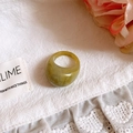Detail shot of an olive green marble resin ring on a delicate white lace background - 34# Ring - Green - Marble Resin