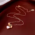 18k gold plated necklace with white heart pendant and beads on textured background - Gold White Heart Style