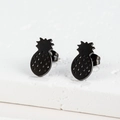 Detailed close-up of pineapple stud earrings in matte black finish on a white stone base - 103 Pineapple / Black