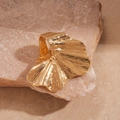 Macro di anello a foglia di ginkgo dorata con texture spazzolata su pietra naturale - Oro
