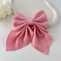 Detail view of large pink satin bow hair clip with ribbons on white decorative tray - Korean Pink