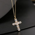 Vue macro d'un collier pendentif croix doré avec des pierres en zircone cubique claires - Style Collier Pave Or (Style 61)