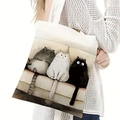Detalle de un bolso de lona con ilustraciones de gatos lindos en el hombro del modelo - Estampado de Tres Gatos en el Sofá