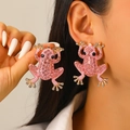 Exaggerated golden frog earrings with pink rhinestones and pearl details worn by model - KC Gold 9821