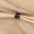 Close-up of a matte black magnetic clip for silk scarves on a beige fabric background - Matte Black