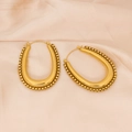 Detalle de pendientes ovalados en U dorados con textura de cadena sobre seda rosa - Estilo de Borde Perlado / Dorado