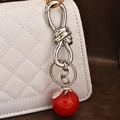 Portachiavi a mela rossa in resina con foglie d'argento su borsa bianca trapuntata - Ciondolo Mela Argento