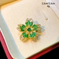 Broche fleur dorée élégante sertie de gemmes émeraude vert en gros plan détaillé - Style Fleur Vert (B802)