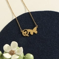 Gold stainless steel necklace with butterfly letter Q and heart pendant on blue display - Gold Q
