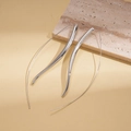 Detailed view of polished silver metal drop earrings on a textured stone display - Minimalist Mirror Polished Curved Taper Ear Thread (1#)
