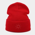 Detailed view of red knitted beanie featuring high-quality white sun embroidery texture - Red