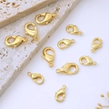 Flat lay of multiple shiny 18K gold plated lobster clasps for DIY jewelry making - 10mm / 18K Gold Plated