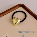 Elastic black hair tie featuring a large gold heart pendant with a polished mirror finish - Gold Smooth Heart