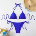Flat lay of navy blue bikini with gold heart rings and summer vacation accessories - Blue