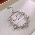 Detailed macro view of adjustable heart zircon bracelet with pink and blue stones - Style with Five Pink Hearts and Three Round Blue Diamonds / Silver