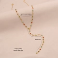 Golden Y-shaped necklace featuring vibrant multi-color crystal hearts on a beige fabric base - Heart