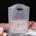Matte Plastik-Geschenktüte mit rosa Rosenmuster und Wellenkante mit Griffloch - 35x45cm / Transparente Rose