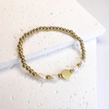 Detail of beaded gold bracelet with baroque pearls and round flat charm on stone - Round / Gold