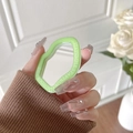 Close-up of a green irregular phone mirror bracket with minimalist quote engraving - Green