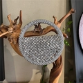 Dettaglio borsa a mezzaluna con perline argentate e manico rotondo su supporto di legno - Argento