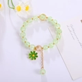 Handmade beaded flower bracelet with green crystal beads and daisy charm on white background - Green
