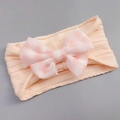 Pink knit baby headband featuring a large plaid tulle bow on a clean grey background - Apricot