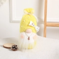 Yellow Christmas knitted gnome figurine with white beard and penguin charm on a wood stand - Yellow