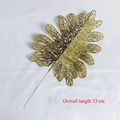 Close-up of golden glitter decorative leaves with 33cm total length and hollow veins - Philodendron Leaf