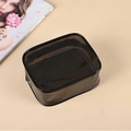 Translucent black PVC cosmetic bag with black trim and zipper on a flat beige background - Solid Color / Black