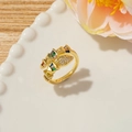 Detail of a gold snake-style ring with colorful rectangular gems on a white ceramic plate - Style I (Geometric Multi-color)
