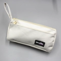 Detail view of double-zippered canvas pencil case with Almost Blue woven label - White