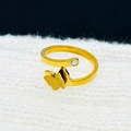 Dettaglio anello a farfalla dorato con texture satinata su morbido tessuto bianco - Anello / Oro