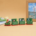 Detail of green wooden Christmas train with Santa, snowman and gift icons on beige background - Green