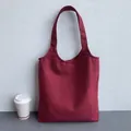 Detail shot of the wine red canvas tote bag showing thick fabric texture and sturdy straps - Red