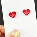 Detail of red heart earrings with white heartbeat lines and glitter finish on card - Red Glitter Heartbeat